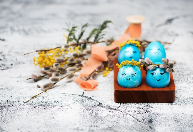 Easter blue eggs with wreaths of spring flowers. Happy easter concept