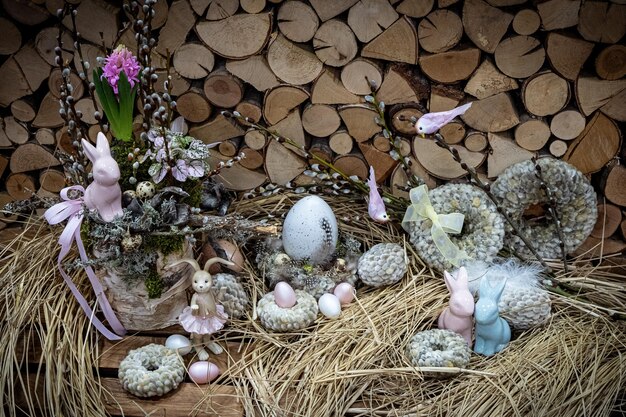 Easter bouquet composition with colorful eggs in nest on wooden background