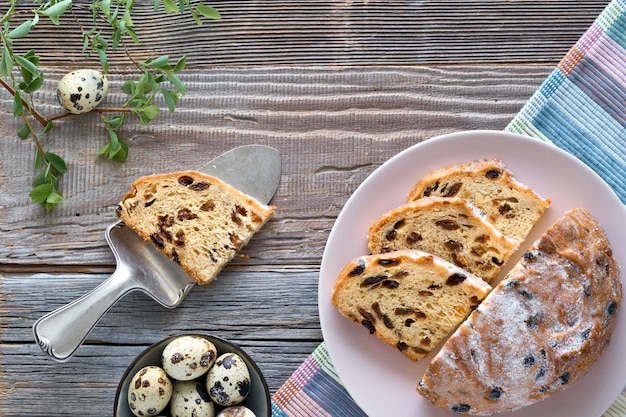 부활절 빵 (독일어 Osterbrot). 신선한 잎과 메 추 라 기 계란 소박한 나무 테이블에 전통적인 과일 빵의 상위 뷰.