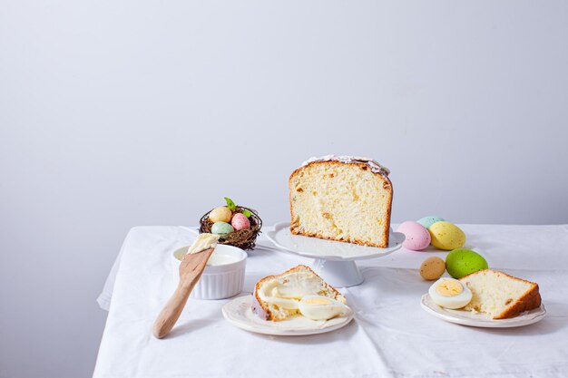 부활절 빵과 계란을 곁들인 부활절 아침 식사를 자르고 하얀 접시에 올려 놓으십시오. 전통적인 부활절 음식이 있는 휴일 테이블
