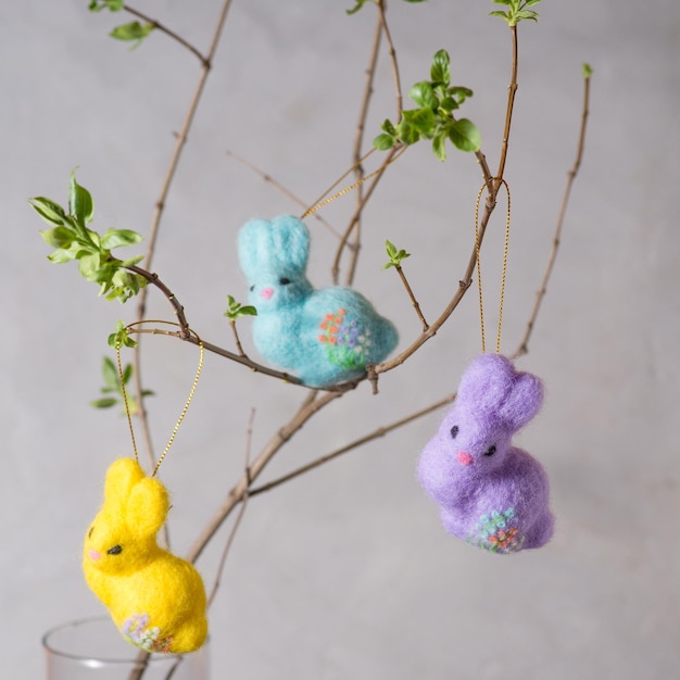 Easter bunnies made of wool on a flowering branch Wool decor for home decoration