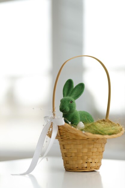 Foto coniglietto di pasqua in un cesto in un cesto cesto con foglie verdi sul fieno sfondo del concetto di vacanza di pasqua copia spazio sfondo bianco