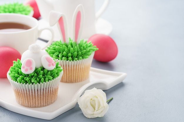 Foto bigné di estremità e orecchie del coniglietto di pasqua con uova e tè per dessert.