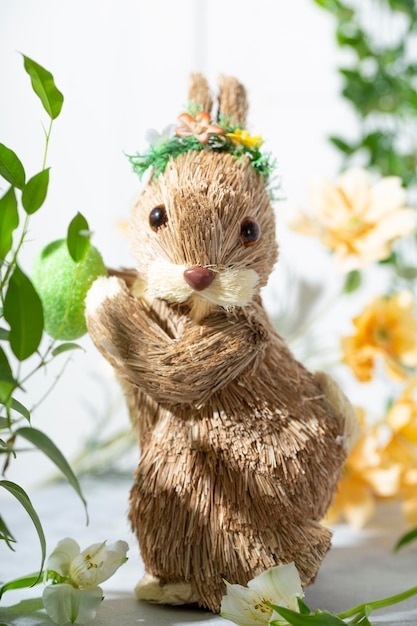 Coniglietto di pasqua uova colorate e fiori di primavera sullo sfondo bianco festosa carta verticale di pasqua