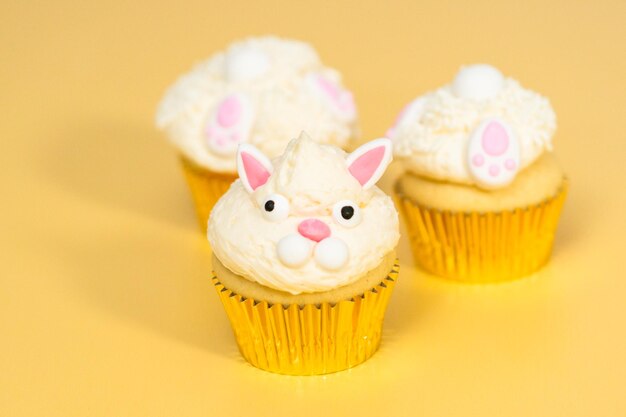 Easter bunny cupcakes on yellow background.