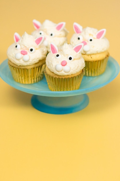 Easter bunny cupcakes on yellow background.