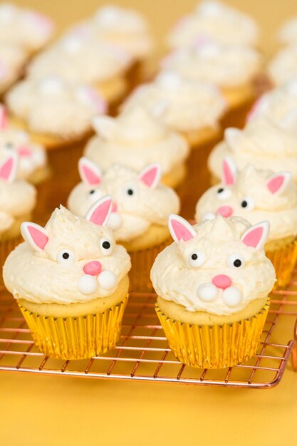 Easter bunny cupcakes on yellow background.