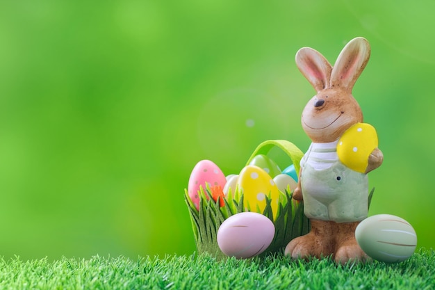 Easter bunny and decorative Easter eggs on a green meadow Easter festive spring composition with copy space