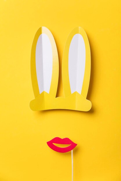 Easter bunny ears and red lips on yellow Minimal lay flat design