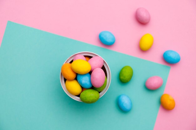 Easter bunny. Happy Easter holiday background concept.Flat lay colorful bunny egg with accessory to celebration on modern rustic pink pastel paper at home office desk.