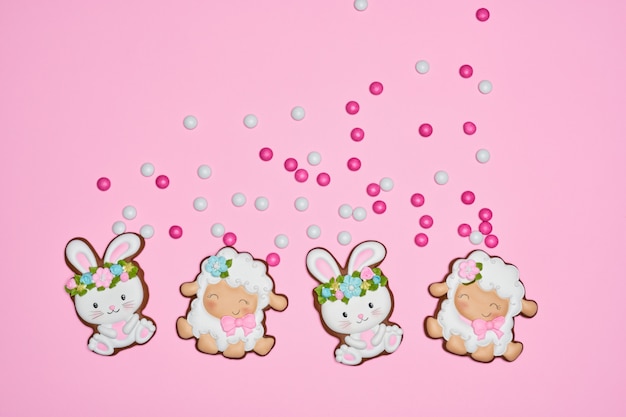 Easter bunny and lamb cookies over pink pastel background