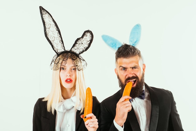 Easter bunny or rabbit couple with carrot funny male female man woman nibbles a carrot like a hare i