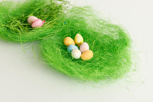 Easter bunny rabbit statuette Close up copy space Easter eggs Chicken eggs twigs with green leaves on the hay Easter holiday concept background Copy space