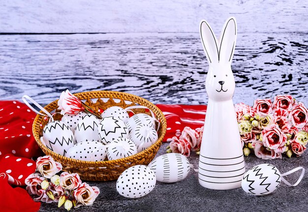 Photo easter bunny white eggs with black polka dots a red shawl eustoma flowers