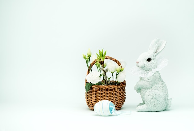 Easter bunny and white spring flowers in a basket and space for text. Happy easter banner