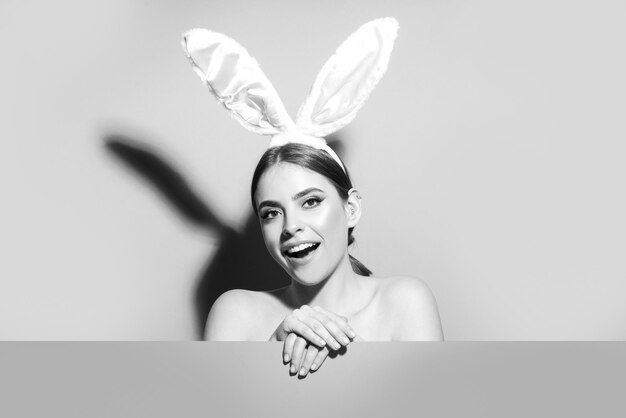 Easter bunny woman with rabbit ears beautiful young girl with on pink blank poster