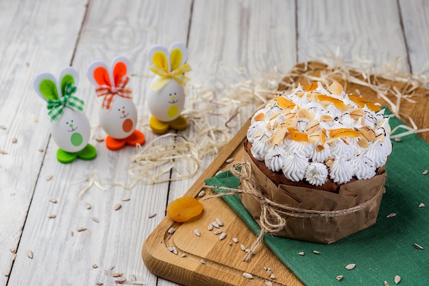 Easter cake bread decorated with eggs candies dried apricots and sunflower seeds on wooden background Holidays concept