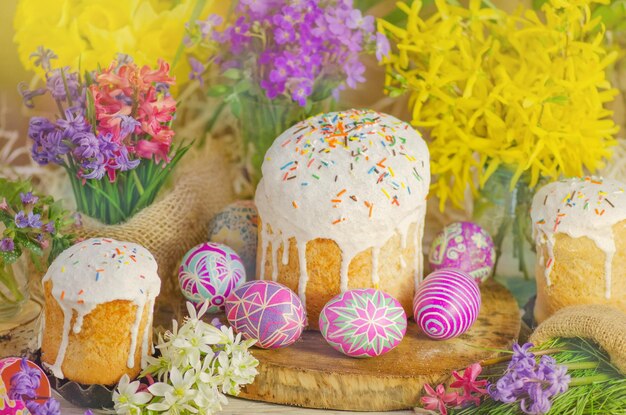 Easter cake and colored eggs on wooden background