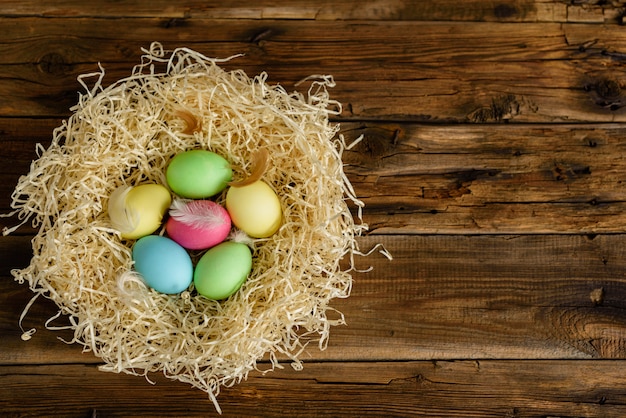 Photo easter cake and colorful eggs on a wooden table.