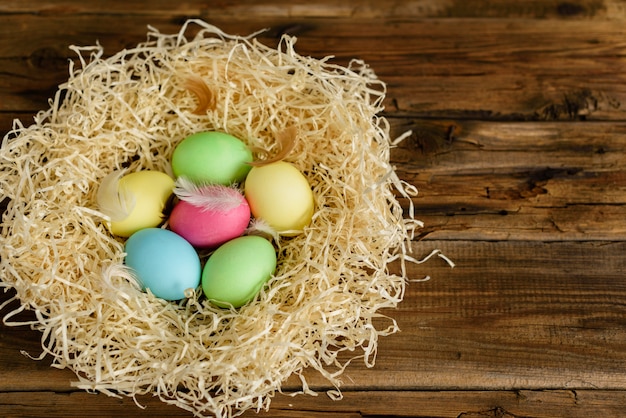 Easter cake and colorful eggs on a wooden table. 