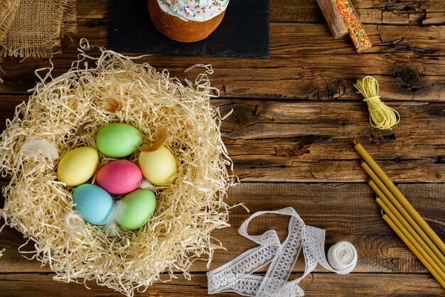 Easter cake and colorful eggs on a wooden table. 