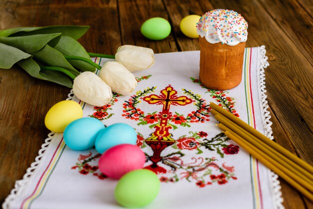 Easter cake and colorful eggs on a wooden table. 