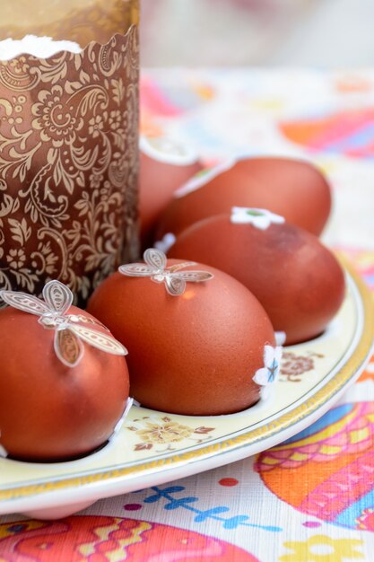 Easter cake and decorated chicken eggs laid out on a plate. Easter tradition: chicken eggs are exchanged and they say: "Jesus is Risen!" Easter celebrations.