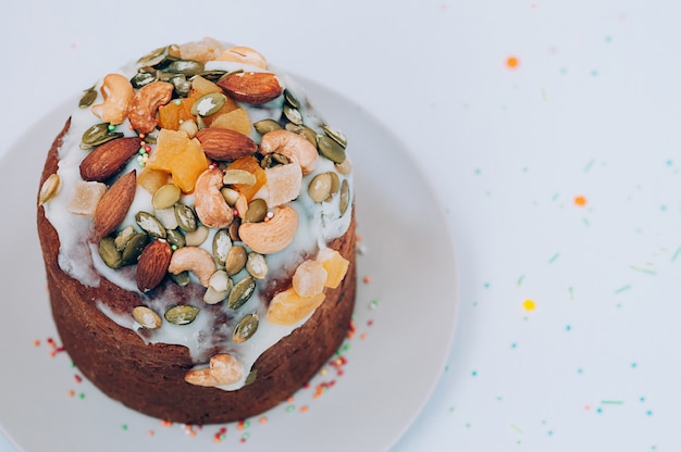 easter cake decorated with icing, nuts and candied fruits