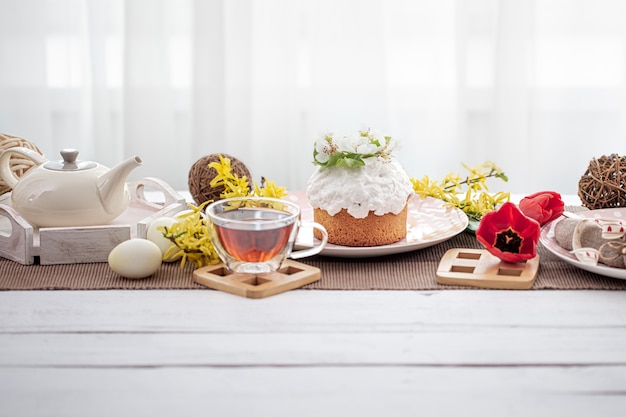 Torta di pasqua, uova, fiori e dettagli di arredamento sul tavolo. concetto di vacanza in famiglia di pasqua e messa in tavola.