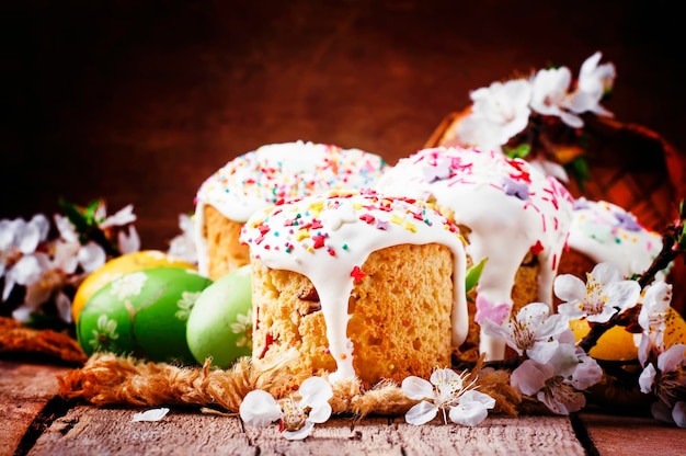 Easter cake and green and yellow painted eggs white apricot flowers festive composition in rustic style russian orthodox tradition vintage wooden background selective focus