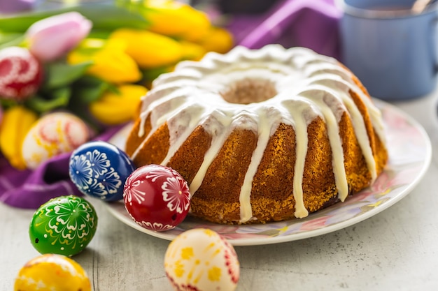 부활절 케이크. 부활절 장식이 있는 전통적인 링 대리석 케이크. 부활절 달걀과 봄 튤립입니다.