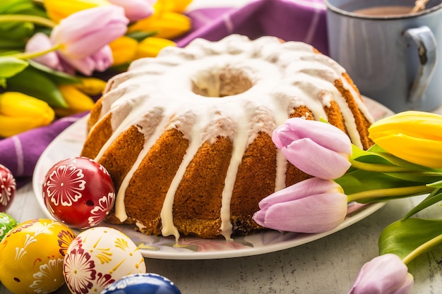 부활절 케이크. 부활절 장식이 있는 전통적인 링 대리석 케이크. 부활절 달걀과 봄 튤립입니다.