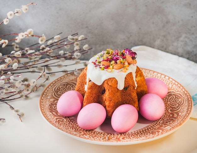 Foto torta di pasqua con uova pasquali dipinte su un tavolo