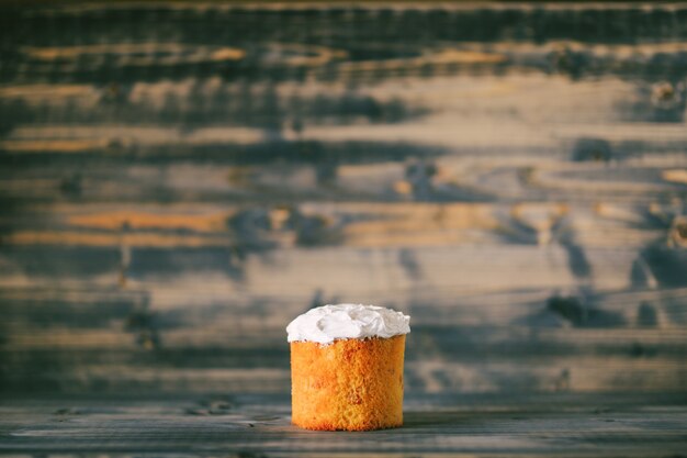 Easter cake with white cream on a wooden background