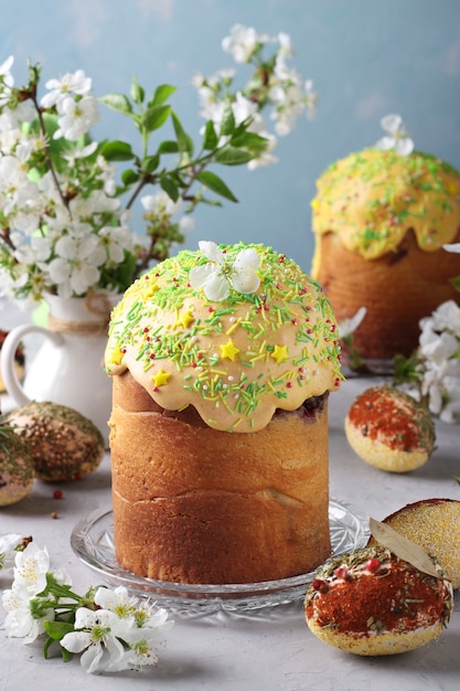 Easter cakes with colored glaze and decoration sprinkling and Easter eggs decorated with spices and cereals, Vertical format, Closeup