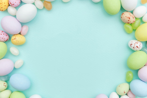 Easter candy chocolate eggs and jellybean sweets isolated on blue table