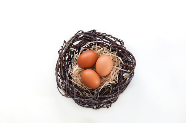 Easter! Chicken eggs in a nest with branches, agriculture. Easter eggs on the table in the nest.