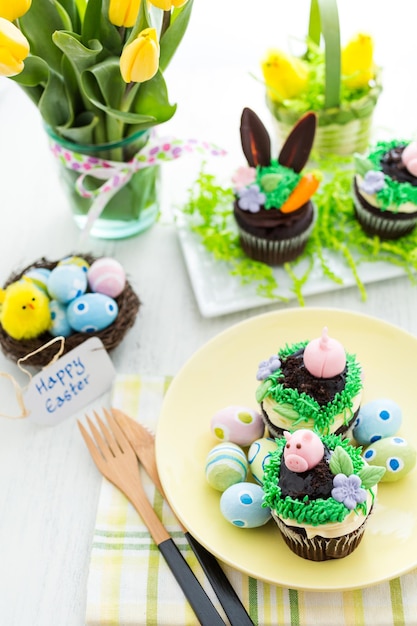 Easter chocolate cupcakes decorated with piggy and bunny ears.