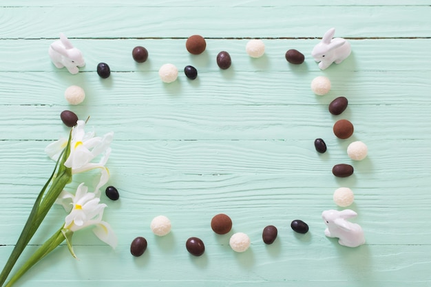 緑の木の表面にイースターチョコレートの卵と花