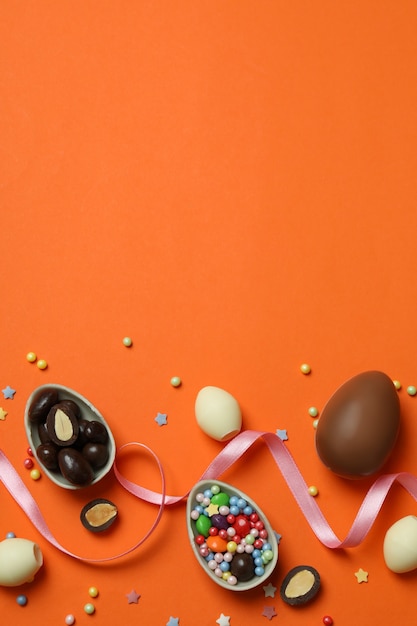 Easter chocolate eggs, candies and sprinkles on orange
