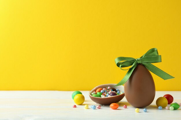 Easter chocolate eggs and candies on white wooden table