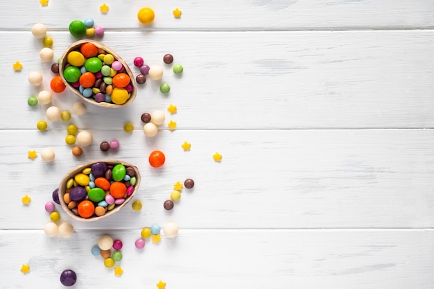 イースター。コピースペースと白い背景の上のチョコレートの卵と色のお菓子