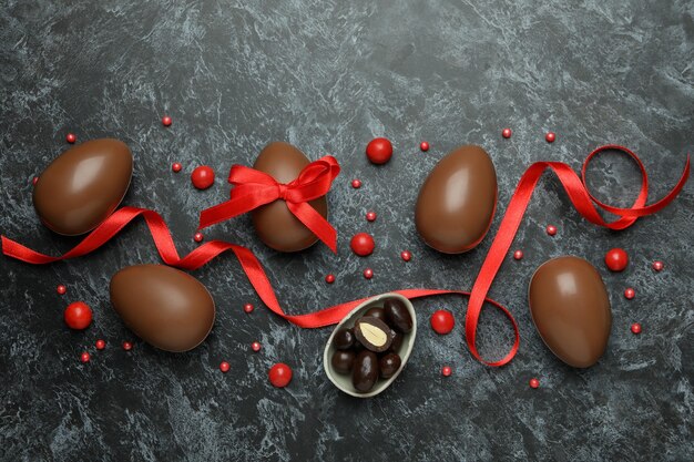 Пасхальные шоколадные яйца с конфетами на черной дымной стене