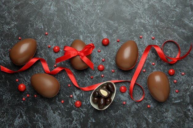 Easter chocolate eggs with candies on black smokey wall