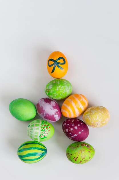 Easter colorful eggs are laid in the shape of a man on white background top view