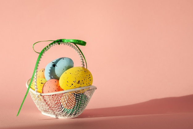 Easter colorful eggs in the basket of coral background