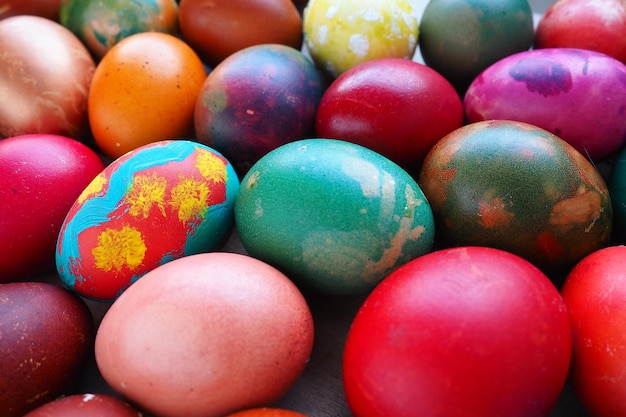 Easter colorful eggs close up Many colorful holiday eggs are stacked close to each other Boiled chicken eggs with floral and fantasy pattern Bright Easter background