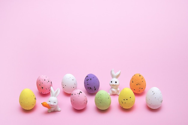 Le uova colorate di pasqua si trovano in due file e tra di loro lo spazio del coniglietto di pasqua per il testo