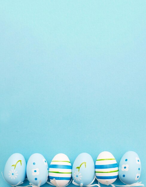 Easter colorful handmade painted eggs on blue background with copy space banner