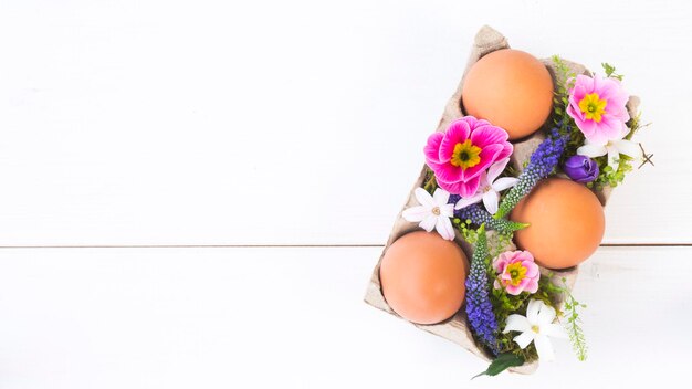 Photo easter composition of chicken eggs and spring flowers